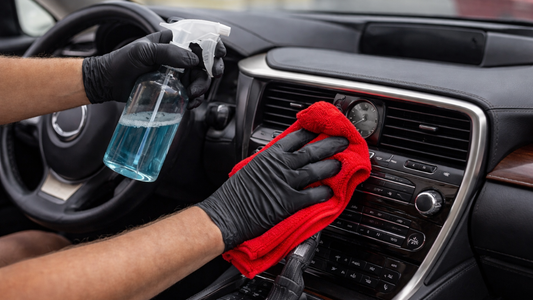 Detailer performing Shop Auto Detailing on luxury vehicle interior, wiping dashboard during professional Mobile Auto Detailing comparison.
