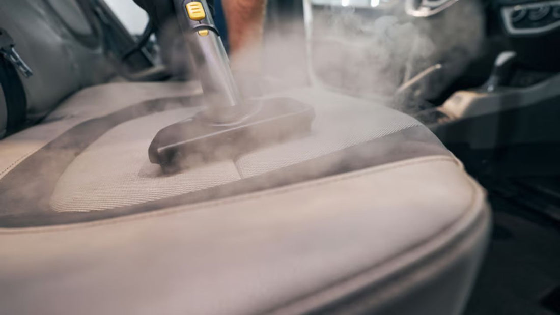 Steam cleaning tool removing dirt from fabric car seat during car interior steam cleaning